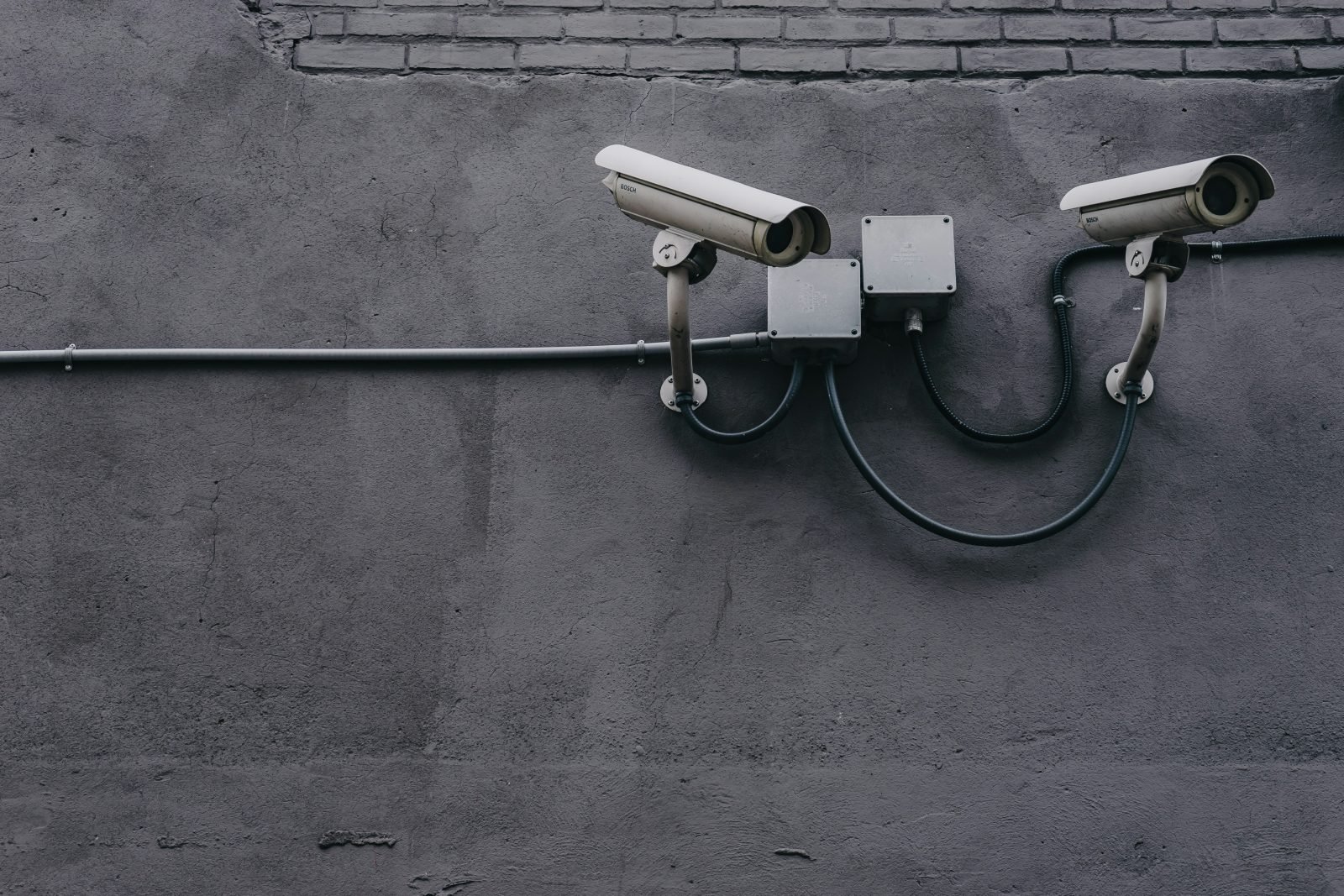 Deux caméras de surveillance sur un mur de béton